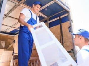 Due operai trasportano un mobile nel furgone per lo sgombero del garage