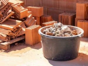 secchio con calcinacci con mattoni sullo sfondo per lavori edili di costruzione