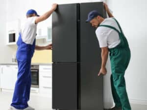 traslocatori mentre spostano un frigo per il trasporto