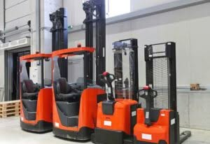 carrelli elevatori rossi di diverse grandezze in un magazzino
